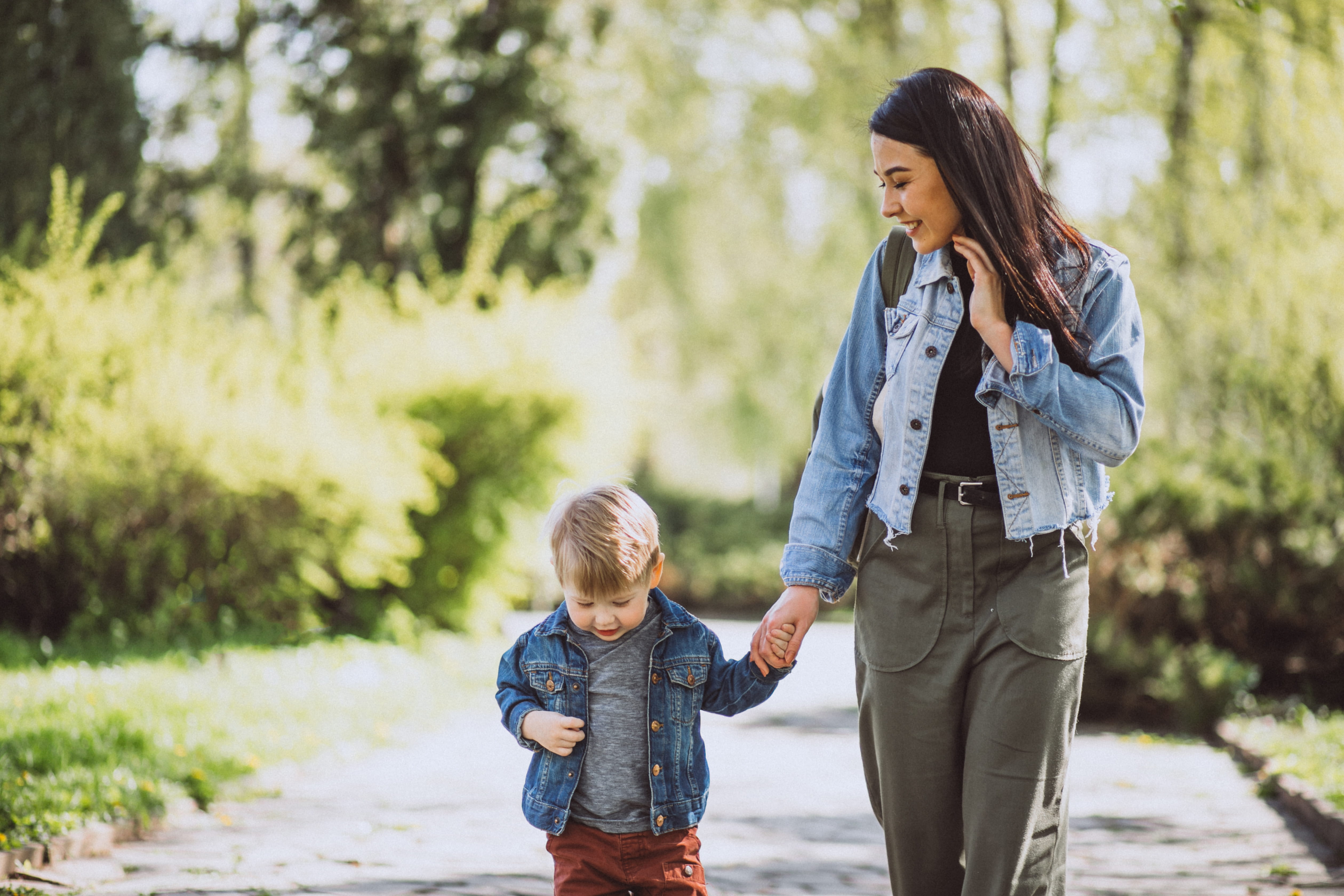 Moeder en zoon lopen hand en hand in het bos